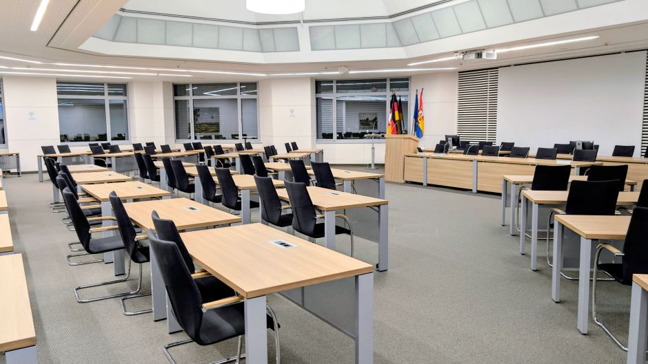 Participação Cidadã — Spacious and modern meeting room in Niedersachsen, Germany, with desks and flags.